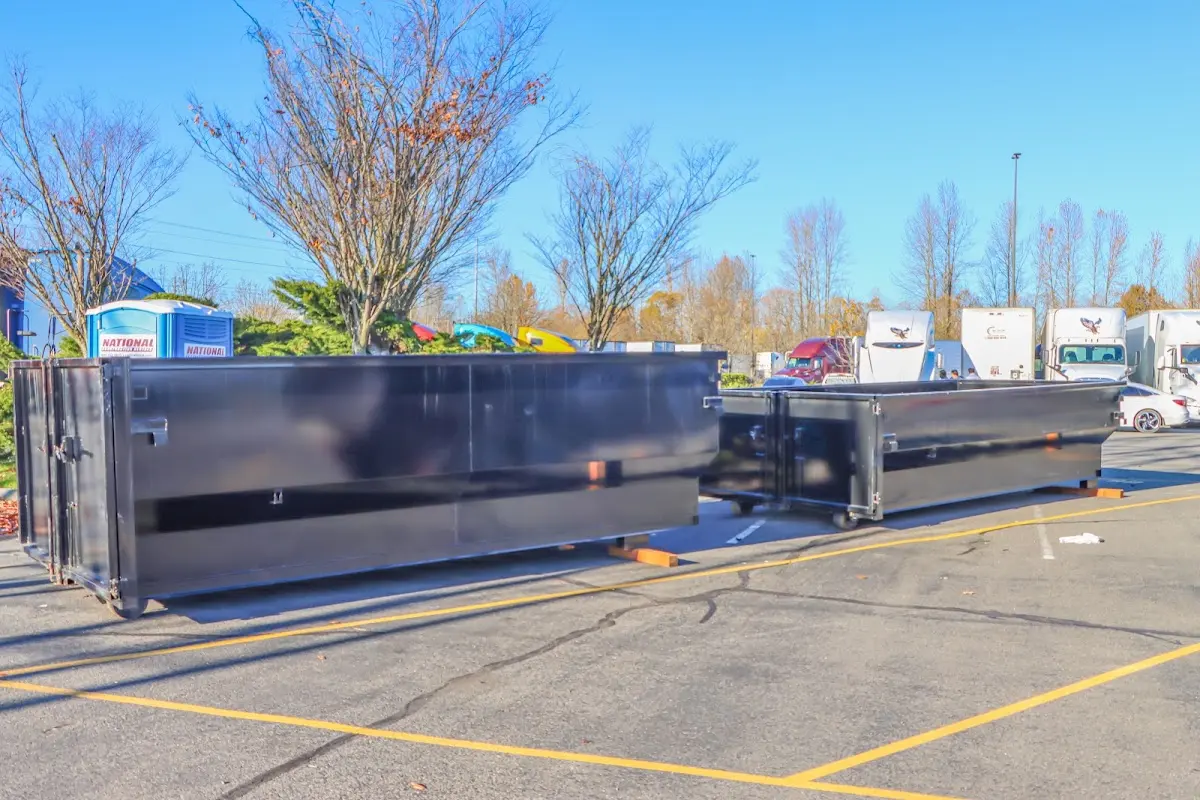 Professional dumpster rental service with roll-off container on residential driveway in Bloomington
